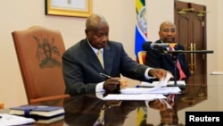 Rais wa Uganda Yoweri Museveni akisaini mswada dhidi ya mashoga na kuwa sheria mwaka 2014, katika ikulu ya rais ya Entebbe, February 24, 2014. 