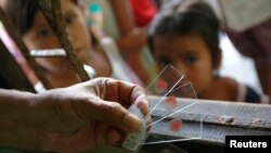 រូបថតឯកសារ៖ មន្ត្រី​ក្រសួង​សុខភាព​សាធារណៈថៃ កាន់​សំណាក​ឈាម​ដែល​បាន​ធ្វើ​តេស្តទៅ​លើ​កុមារ​ដែល​រស់​នៅ​តាម​ព្រំដែន​ថៃ​-មីយ៉ាន់ម៉ា នៅ​ឯ​ក្លីនិក​ព្យាបាល​ជំងឺ​គ្រុន​ចាញ់​ក្នុង​ខេត្ត Kanchanaburi ប្រទេស​ថៃ កាលពីថ្ងៃទី​២៦ ខែ​តុលា ឆ្នាំ២០១២។