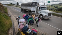 Migrantes venezolanos descansan durante su travesía a pie hacia Bogotá, en Tunja, Colombia. el 6 de octubre de 2020.