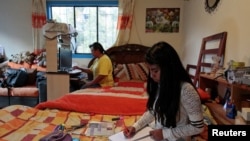 Claudia Bustillos, de 17 años, toma clases en línea en casa mientras su madre María Elena trabaja en una computadora en medio del brote de la enfermedad por coronavirus (COVID-19) en La Paz, Bolivia, 1 de septiembre de 2020.