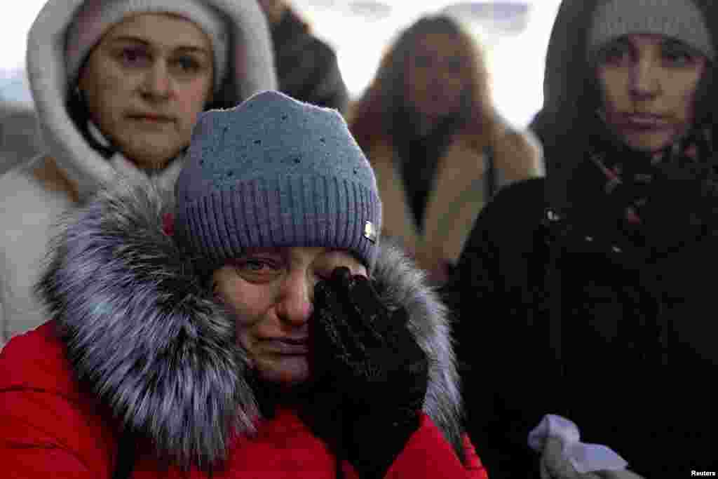 People attend a memorial event marking the 3rd anniversary of Russia's invasion of Ukraine at Romanivska Bridge that was destroyed at the beginning of the war in Irpin outside in Kyiv, Ukraine.