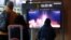 FILE - People watch a TV broadcasting a news report on North Korea firing a ballistic missile into the sea off its east coast, at a railway station in Seoul, South Korea, March 16, 2023. 