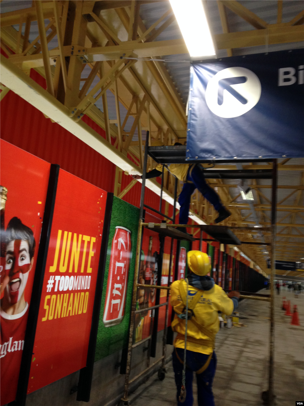 Workers make a final push to complete sections of the stadium just days before World Cup events start, June 10, 2014. (VOA/Nicolas Pinault)