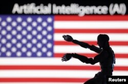 រូបឯកសារ៖ រូបភាពថតកាលពីថ្ងៃទី២១ ខែធ្នូ ឆ្នាំ២០២៣ បង្ហាញពាក្យ AI ដែលប្រែថាបញ្ញាសិប្បនិម្មិត និងទង់ជាតិ​អាមេរិកនៅពីក្រោយ​រូបយន្តមួយ។