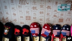FILE - Chinese-made children shoes carrying a Chinese map and U.S. flags are on display for a sale at a shop in Beijing, July 13, 2018. 