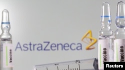 A test tube labeled with the Vaccine is seen in front of AstraZeneca logo in this illustration, Sept. 9, 2020.