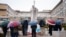 Pessoas rezam debaixo de chuva junto à estátua de João Paulo II no Hospital Universitário Gemelli, onde o Papa Francisco está hospitalizado com pneumonia, em Roma, a 1 de março de 2025.