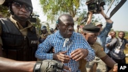 Le chef de l'opposition ougandaise Kizza Besigye, centre, est arrêté par la police à Kasangati, en Ouganda le 22 février 2016.