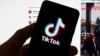 Le logo de TikTok est visible sur un téléphone portable devant un écran d'ordinateur qui affiche l'écran d'accueil de TikTok, le samedi 18 mars 2023, à Boston. (AP Photo/Michael Dwyer, File).