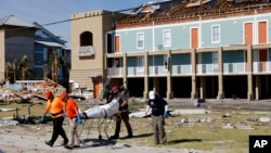 A body is removed after being discovered during a search of a housing structure in the aftermath of Hurricane Michael in Mexico Beach, Florida, Oct. 12, 2018.