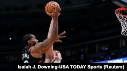 Kawhi Leonard, à gauche, contre le pivot des Denver Nuggets, Nikola Jokic, Denver, Colorado, le 16 décembre 2018. 