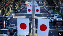 资料照: 日本东京一条商业街上悬挂的日本国旗. (2023年1月3日)